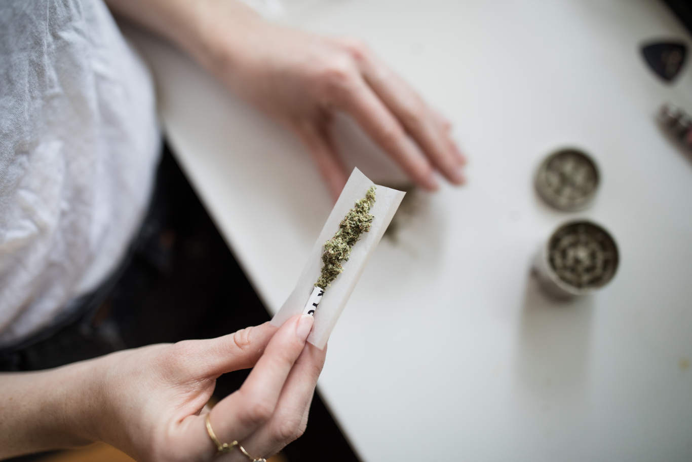 Woman rolling a marijuana joint.